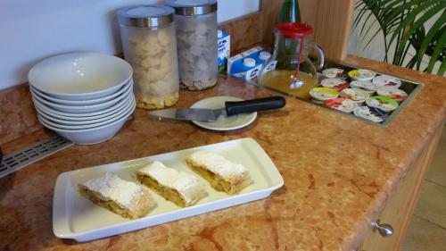 a counter top with a plate of cake and plates at Agritur Maso Barco in Faedo