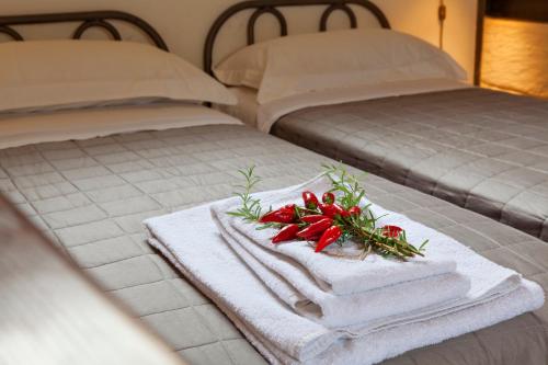 two beds with towels and flowers on top of them at Buon Consiglio B&B in Lecce