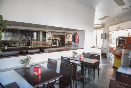 un restaurante con mesas y sillas y un bar en Hostal DP El Pilar en Monesterio