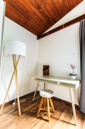 a desk in a room with a lamp and a stool at Villa delle Palme in Coglio