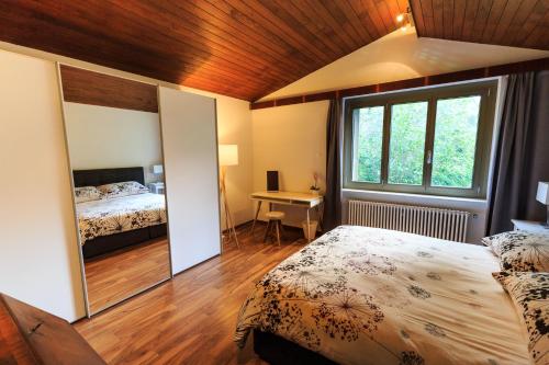 1 dormitorio con 2 camas, escritorio y ventana en Villa delle Palme, en Coglio