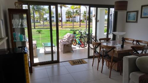 sala de estar con mesa y sillas y vistas a un patio en Apartamento Residencial Mediterrâneo Iberostate Praia do Forte, en Mata de Sao Joao
