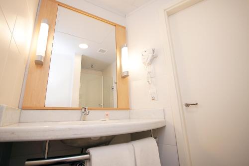 a bathroom with a sink and a mirror at ibis Montenegro in Montenegro