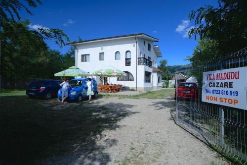 a woman standing in front of a building with an umbrella at Vila Madudu in Vălenii de Munte