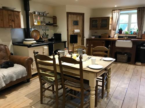 a kitchen and living room with a table and chairs at Pleck Barn B&B in Ansty