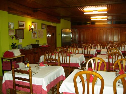 a dining room with tables and chairs in a restaurant at Hostal l'Escon in Llanars