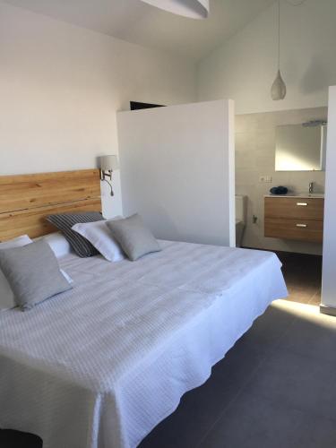 Un dormitorio con una gran cama blanca con almohadas. en Casa Fenix, en Tinajo