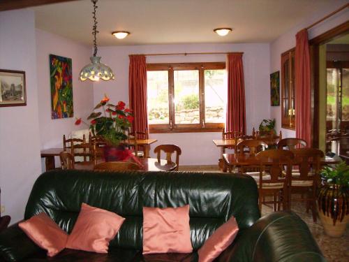 a living room with a leather couch and a dining room at Hostal l'Escon in Llanars