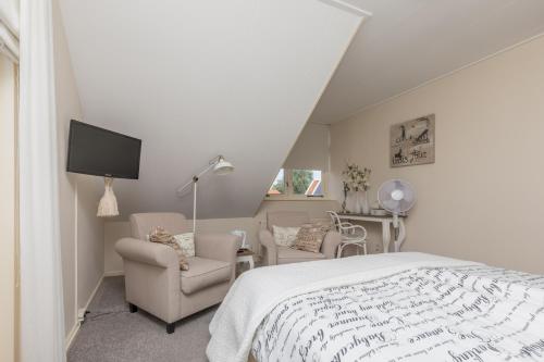 una camera con un letto, due sedie e una TV di Hotel-Restaurant van der Weijde a Noordgouwe