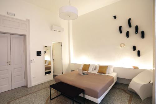 a white bedroom with a bed and a couch at Re Ruggero Rooms in Reggio di Calabria