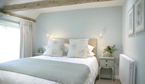 a bedroom with a bed with white sheets and pillows at The Three Hills in Bartlow