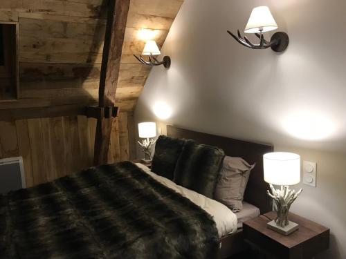 - une chambre avec un lit et deux lumières sur le mur dans l'établissement Les Maisons du Périgord, à Terrasson