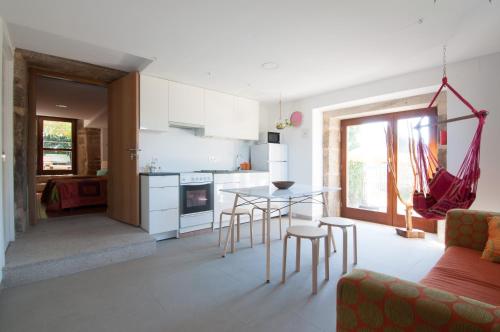 a kitchen and living room with a table and chairs at Outeiro de Setecamiños in Cuntis