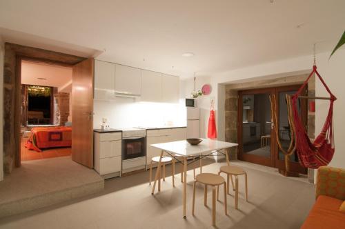 a kitchen with a table and chairs in a room at Outeiro de Setecamiños in Cuntis