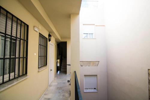 un couloir d'un immeuble avec une porte et un escalier dans l'établissement Apartamentos Aloha 2 Centro El Puerto de Santa Maria, à El Puerto de Santa María