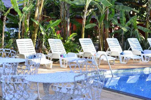 een groep stoelen en tafels naast een zwembad bij Pousada Rancho do Ralf in Pirenópolis