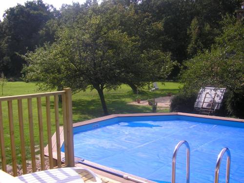une grande piscine bleue sur une terrasse avec une clôture dans l'établissement Les Sapins, à Vitry-aux-Loges