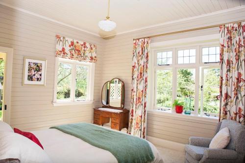 a bedroom with a bed and a mirror and a chair at Leader Valley Cottage - A Tranquil Retreat For Two in Mendip Hills