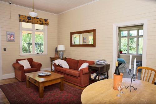 a living room with two couches and a table at Leader Valley Cottage - A Tranquil Retreat For Two in Mendip Hills