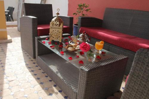 sala de estar con mesa, sofá y sillas en Riad Etoile De Mogador, en Essaouira