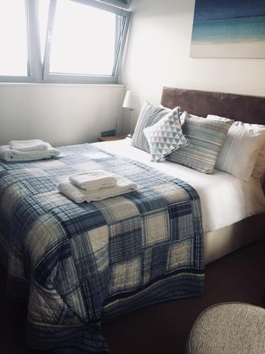 a bedroom with a bed with two towels on it at Sky Night Serviced Apartments in Cardiff