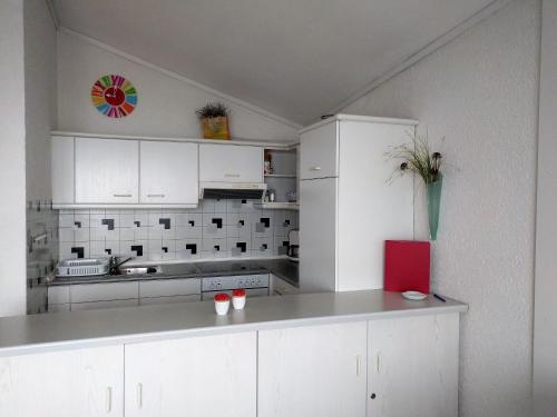 cocina con armarios blancos y encimera en Appartementhaus Himmelreich, en Lam