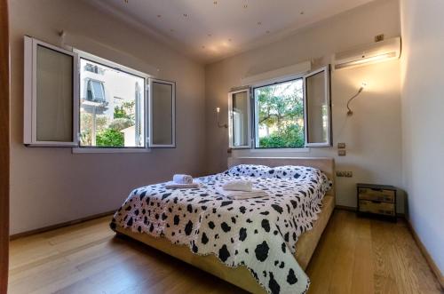 um quarto com uma cama em preto e branco e janelas em Aquarius - Glyfada detached house em Atenas