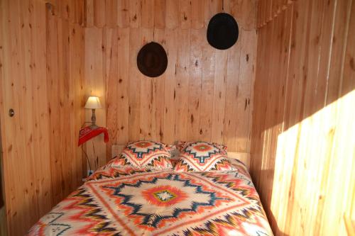 Le Ranch Amadeus في Saint-Paul-en-Born: غرفة نوم بسرير وجدران خشبية
