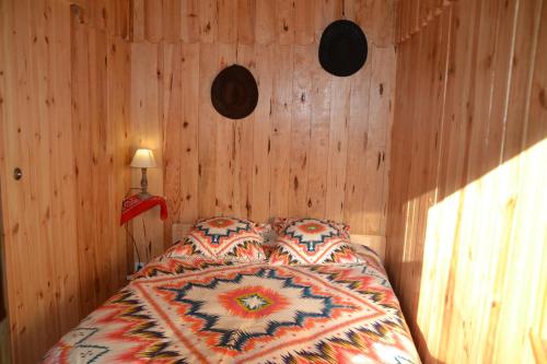 a bedroom with a bed with wooden walls at Le Ranch Amadeus in Saint-Paul-en-Born