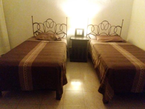two beds sitting next to each other in a room at Posada San Cristobal in Cuernavaca