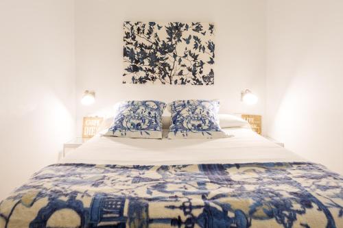 1 dormitorio con 1 cama con colcha azul y blanca en Atrivm Apartamento, en Sevilla