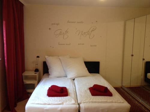 マルクドルフにあるFeWo Familie Waltherの白いベッド(赤い枕2つ付)