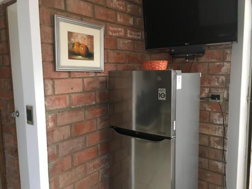 a brick wall with a television and a refrigerator at Bungalows Cerro Azul in Cerro Azul