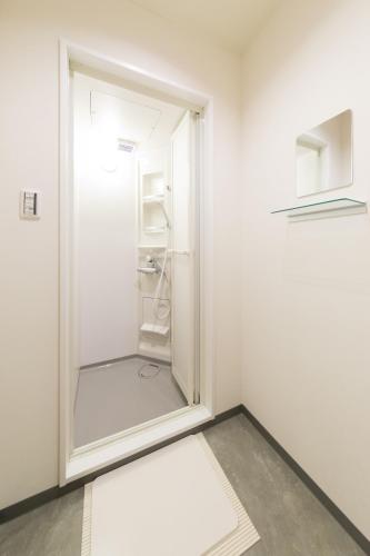 a walk in closet with a glass door at Rota Hostel in Osaka