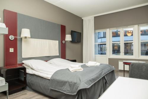 a hotel room with a bed and a television at Oppdal Gjestetun Hotell in Oppdal