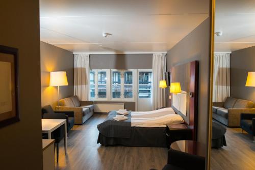 a hotel room with a bed and a living room at Oppdal Gjestetun Hotell in Oppdal