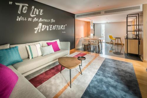 a living room with a couch and a table at M Social Auckland in Auckland