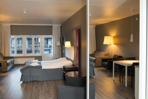 a hotel room with a bed and a living room at Oppdal Gjestetun Hotell in Oppdal