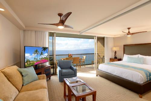 a bedroom with a bed and a living room at Mana Kai Maui - Official Onsite Rental Company in Wailea