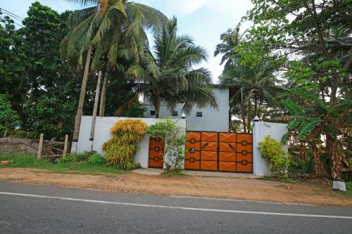 a house with an orange gate on the side of the road at Haus am Meer "Wilde Ananas" in Koggala