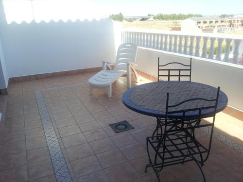 a patio with a table and chairs on a balcony at Hotel Flor de la Mancha in La Roda