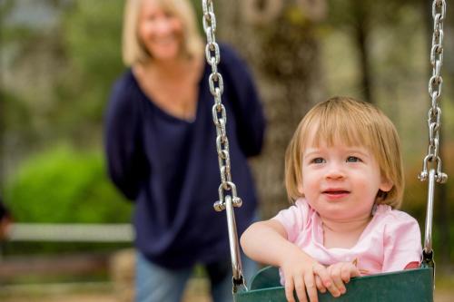 a little girl is sitting in a swing at Discovery Parks - Bright in Bright