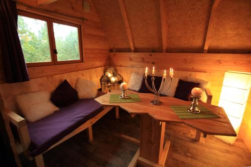 une chambre avec une table et un banc dans une cabine dans l'établissement Le Nid Dans Les Bruyères, à Fère-en-Tardenois