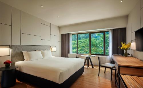 a hotel room with a bed and a desk at PARKROYAL Penang Resort in Batu Ferringhi