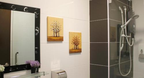 ein Bad mit einer Dusche und 3 Gemälden an der Wand in der Unterkunft H2H - London House @ Majestic Ipoh (8~10 Guests) in Ipoh