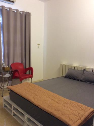 a bedroom with a bed and a red chair at Lan Thai Ngoc Hotel in Cao Lãnh