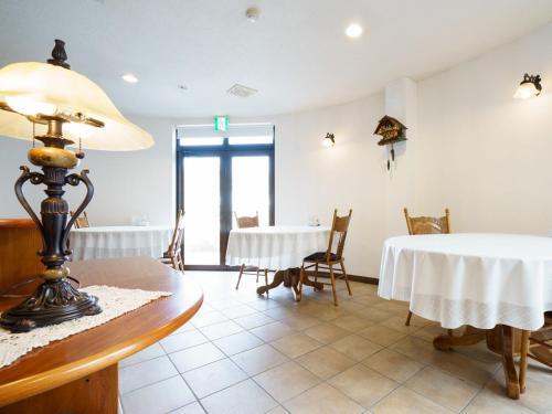 a dining room with a table and a table and chairs at Chez-soi Wakamiya in Gujo