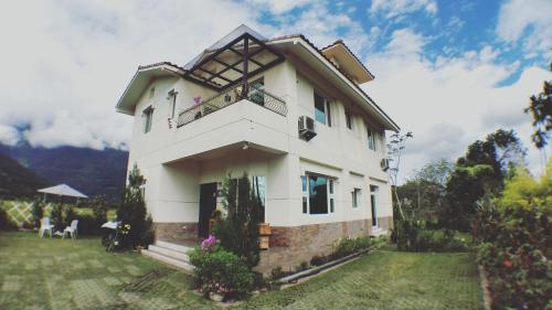 a white house with people sitting in a yard at Home-Link B&B in Fenglin