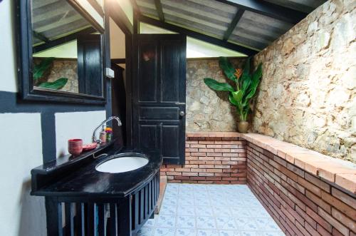 a bathroom with a black sink and a mirror at Hillside - Nature Lifestyle Lodge in Luang Prabang