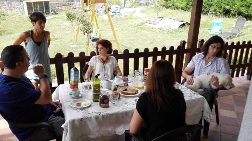 eine Gruppe von Menschen, die um einen Tisch herum sitzen in der Unterkunft La Casona de Palu in Pola de Laviana